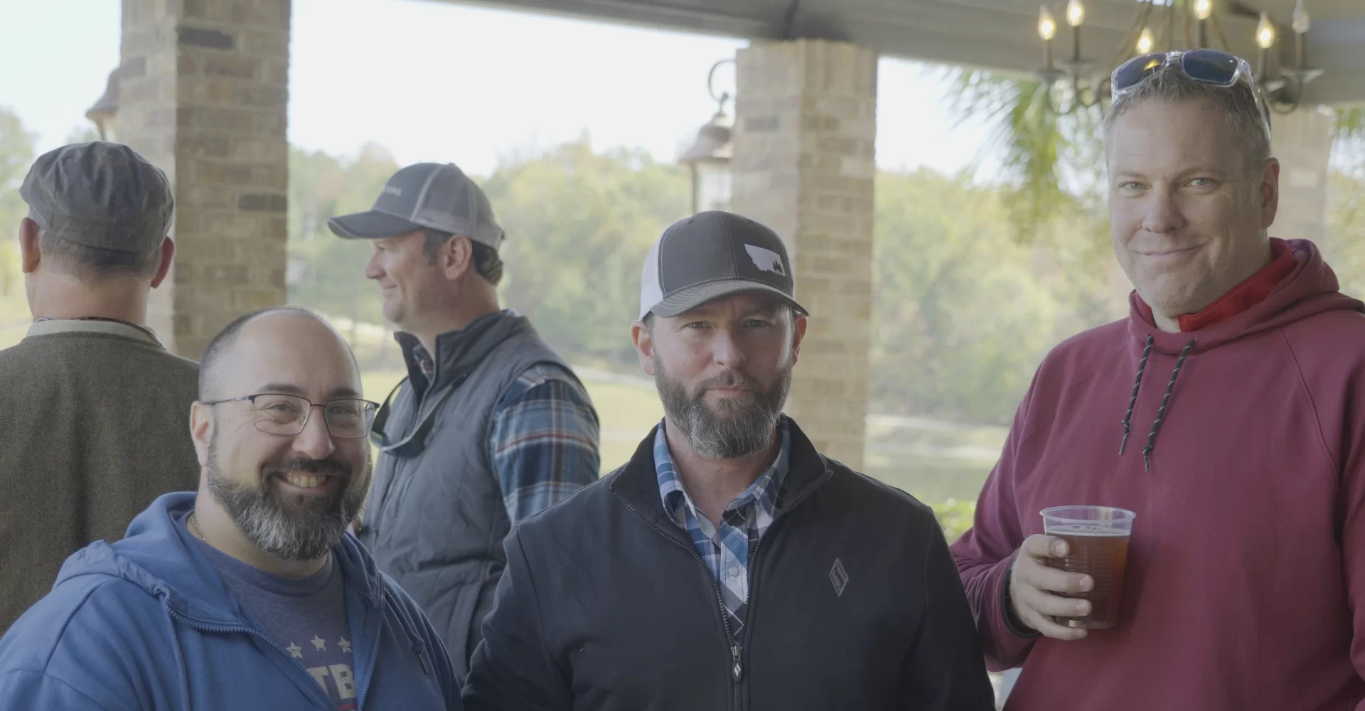 3 people with drinks at past Clays 4 Kids event