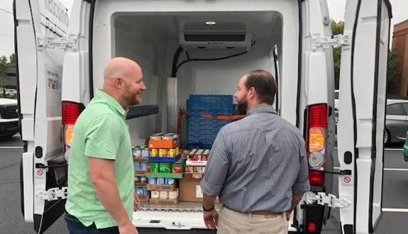 HRP employees loading a van with food donations