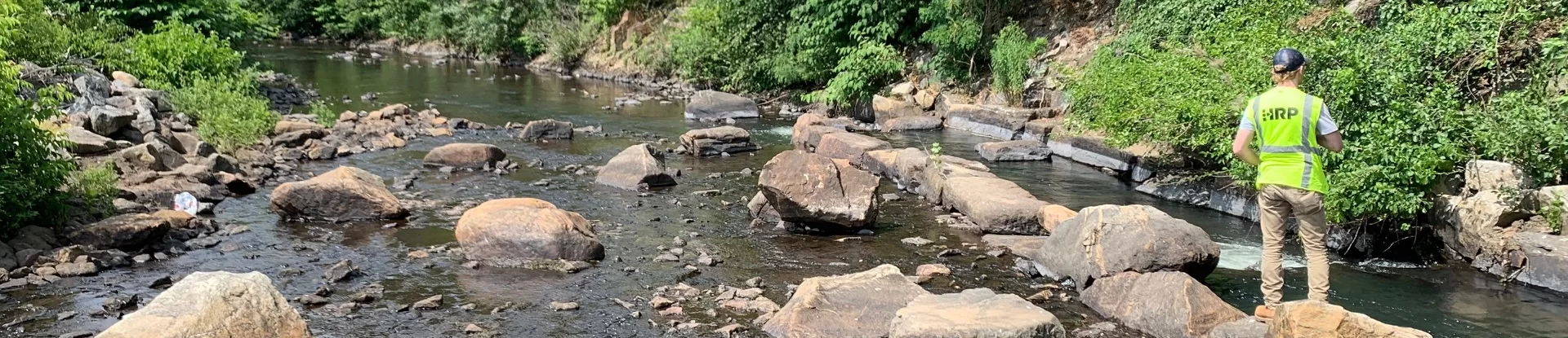 HRP employee standing on river rocks